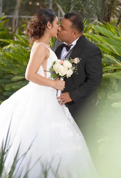 Novios besándose en el jardín